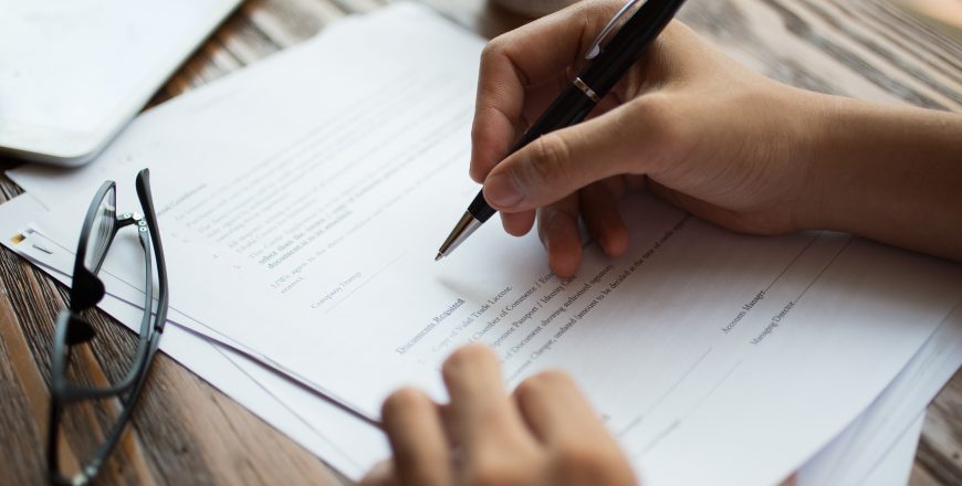 businessman-examining-papers-table.jpg